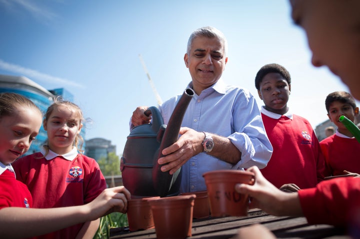 Khan helps schoolchildren plant seeds and flowers