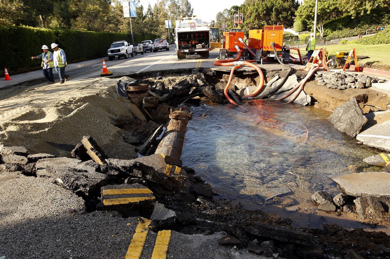 Work crews assess the damage to a ruptured 90-year-old water main in Los Angeles in 2014.