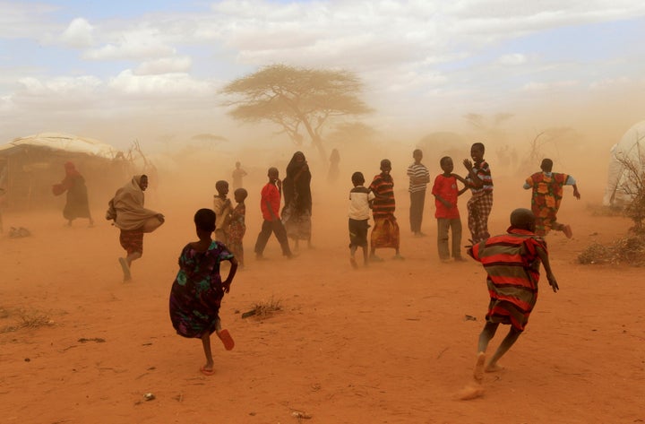 Refugees run from a cloud of dust at the Dagahaley refugee camp in Dadaab.