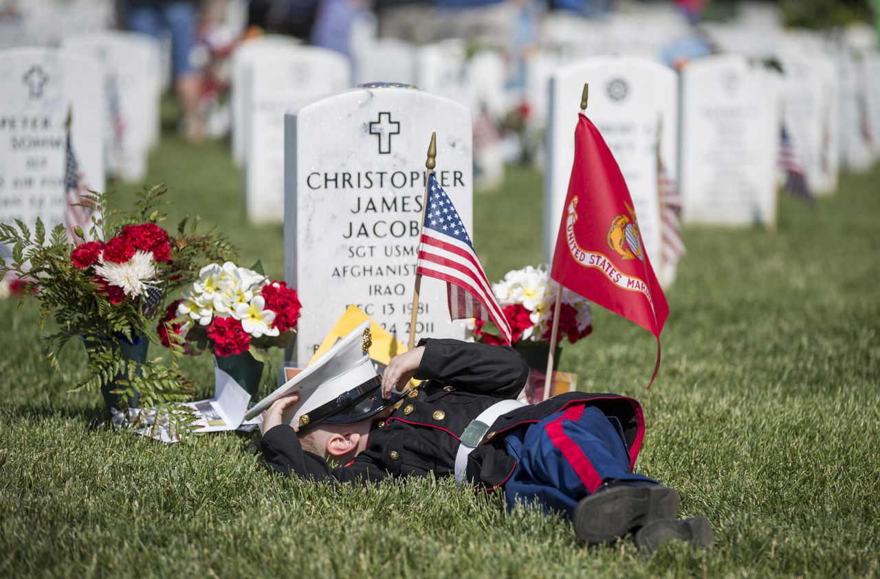 Christian Jacobs, 4, of Hertford, North Carolina, lies on the grave of his father, Christian James Jacob, during a Memorial Day ceremony at Arlington National Cemetery in Arlington, Virginia, on May 25, 2015.