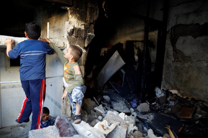 Children play inside a devastated house struck by rocket fire from Syria in Turkey's southeastern border town of Kilis May 10