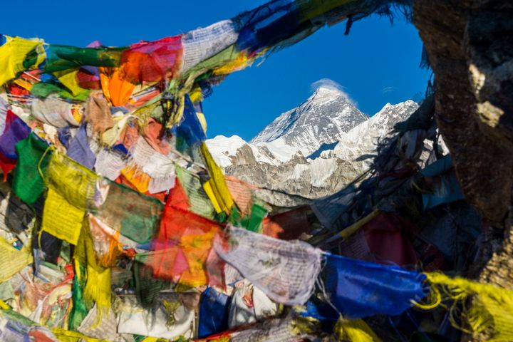 Prayer flags are seen hanging in the foreground of Mt. Everest. Chinese officials say they are going to start blacklisting those who graffiti their names at a surrounding base camp.