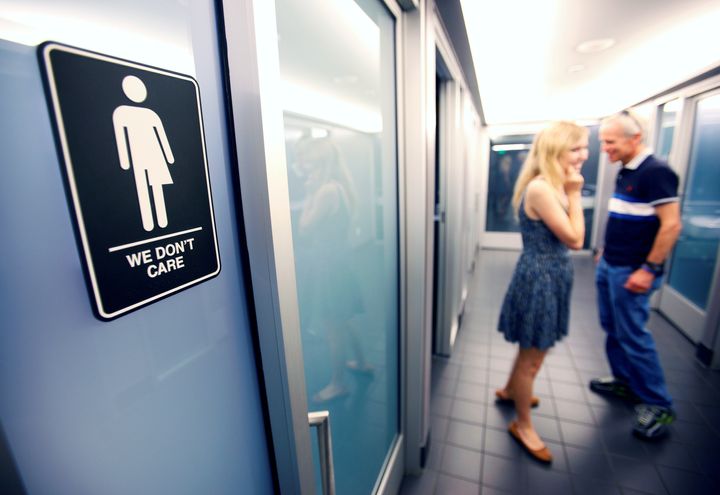 A sign protesting a recent North Carolina law restricting transgender bathroom access adorns a bathroom stall in a North Carolina hotel.