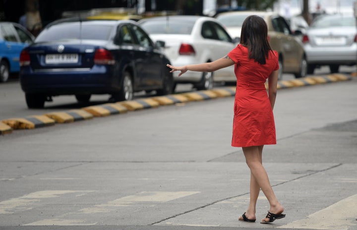 An Indian woman hails a cab in Mumbai, India.