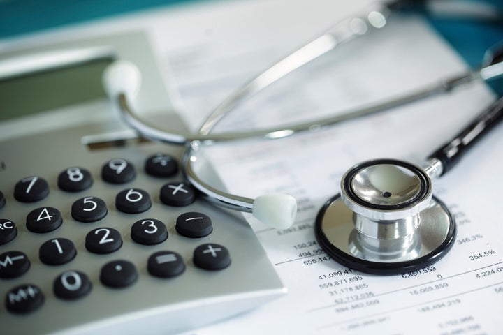 Calculator and stethoscope on financial statement concept for finance health check or cost of healthcare BrianAJackson via Getty Images