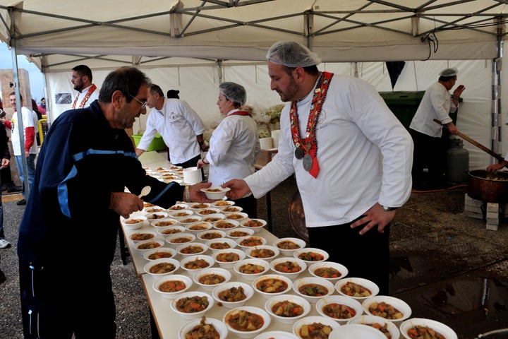 Chefs serve a free meal during an event in Greece.