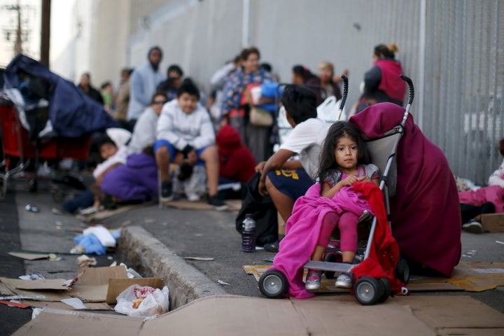 People wait in line at a back to school giveaway of shoes, clothing and backpacks for more than 4,000 homeless and underprivileged children in Los Angeles.