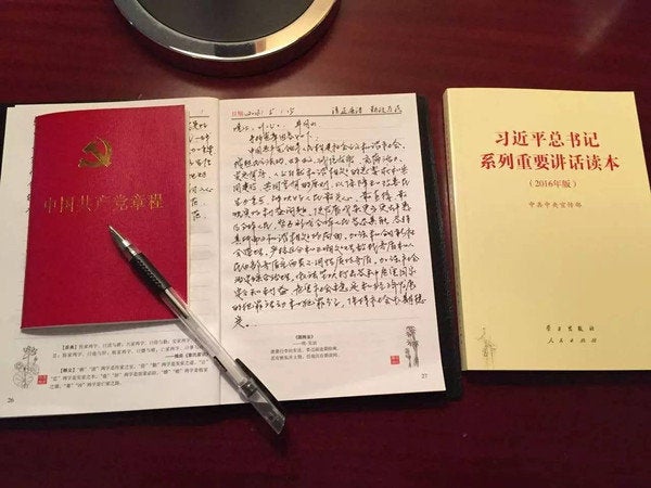 A handwritten copy of the constitution by a Nanchang Railway Bureau employee, placed between booklets of the Chinese constitution and President Xi Jinping's speeches.