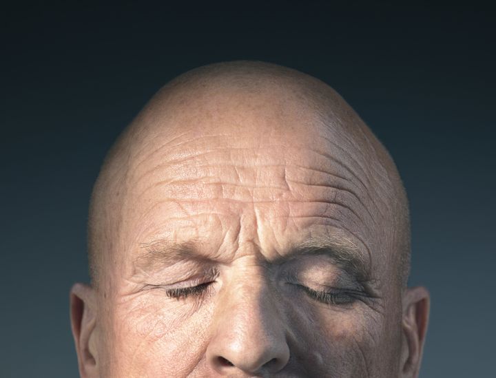 Studio photograph of middle-aged man's head with eyes closed. Tim Flach via Getty Images