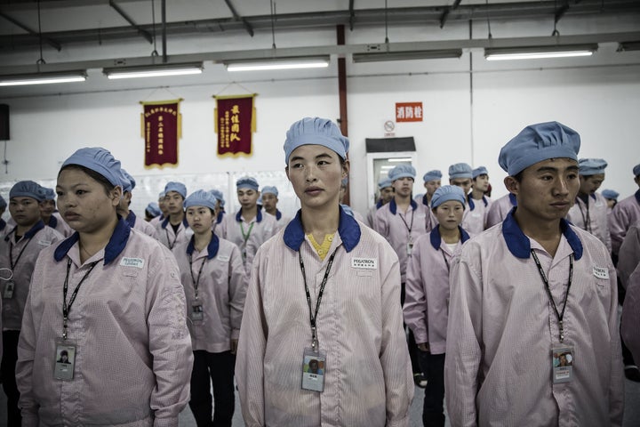 Employees line up for roll call at a Pegatron Corp. factory in Shanghai, China, on Friday, April 15, 2016. This is the realm