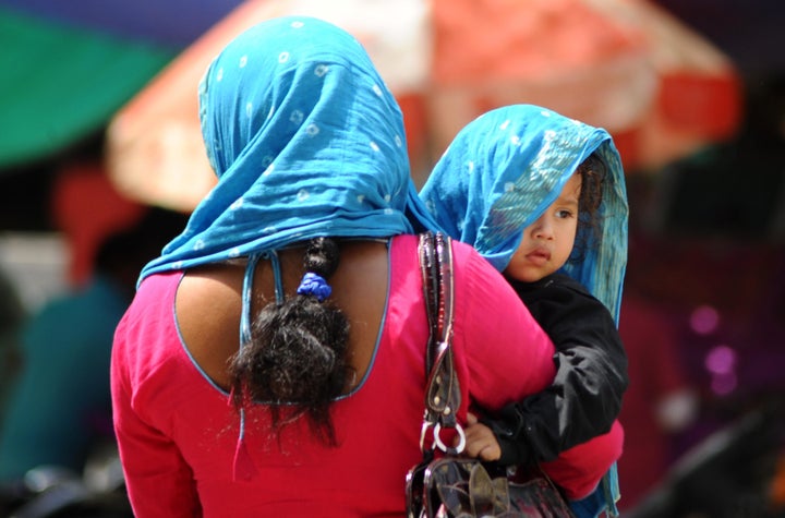 A woman covers herself and her child with a scarf as temperatures soared to record highs.