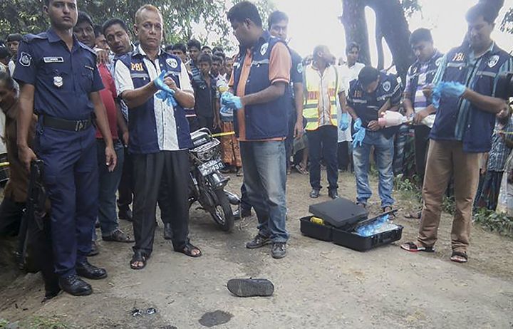 Police in Bangladesh suspect Islamist militants are behind the bloody murder of a village doctor on Friday. Pictured here, investigators look over the body of the 58-year-old victim.