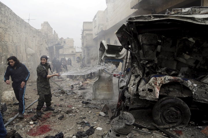A man sprays water on an ambulance at a site hit by what activists said were three consecutive air strikes carried out by the