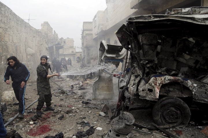 A man sprays water on an ambulance at a site hit by what activists said were three consecutive air strikes carried out by the Russian air force, the last which hit this vehicle, in the rebel-controlled area of Maaret al-Numan town in Idlib province, Syria January 12, 2016.