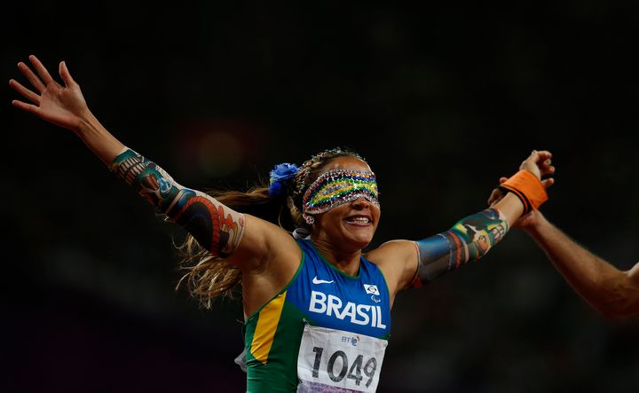 Brazil's Terezinha Guilhermina is held by her guide as she celebrates winning the women's 100m - T11 final in the Olympic Stadium at the London 2012 Paralympic Games. 