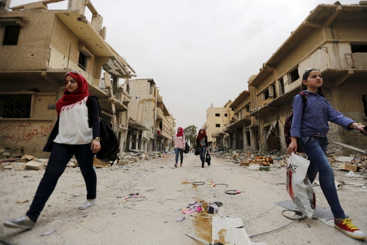 More and more women are at the forefront of efforts to solve local problems and to counter the violence in Syria. Above, women carry their belongings from damaged homes in the Syrian city of Palmyra.