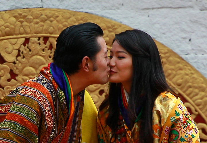 Bhutan's King Jigme Khesar Namgyal Wangchuck, left, and Queen Jetsun Pema kiss in front of the crowd at the main stadium as p
