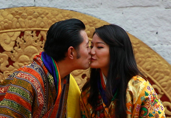 Bhutan's King Jigme Khesar Namgyal Wangchuck, left, and Queen Jetsun Pema kiss in front of the crowd at the main stadium as part of their wedding celebrations.