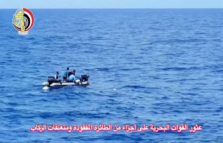 Men on a military dinghy boat remove an object from the sea as they recover debris of the crashed EgyptAir jet on May 21, 2016.