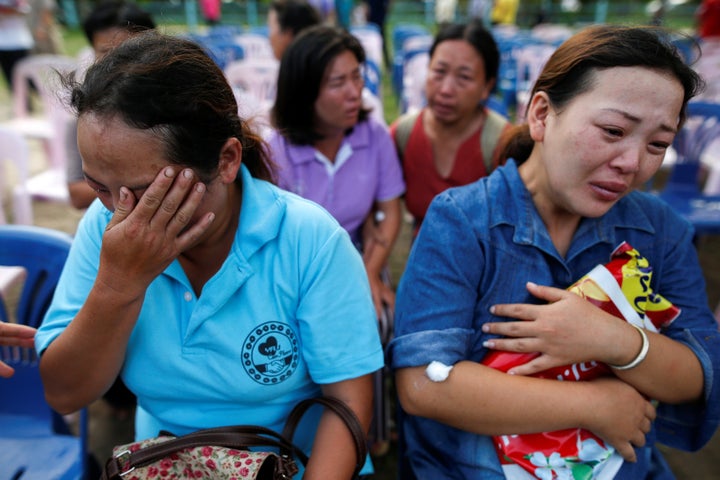 Women who lost their daughters to the fire mourn near the Pitakiatwittaya School, where the fire took place.