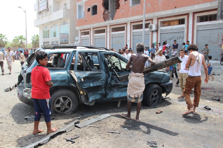 People inspect the site of the suicide bombing in Aden.