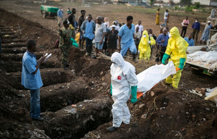Health workers carry the body of an Ebola victim for burial at a cemetery.
