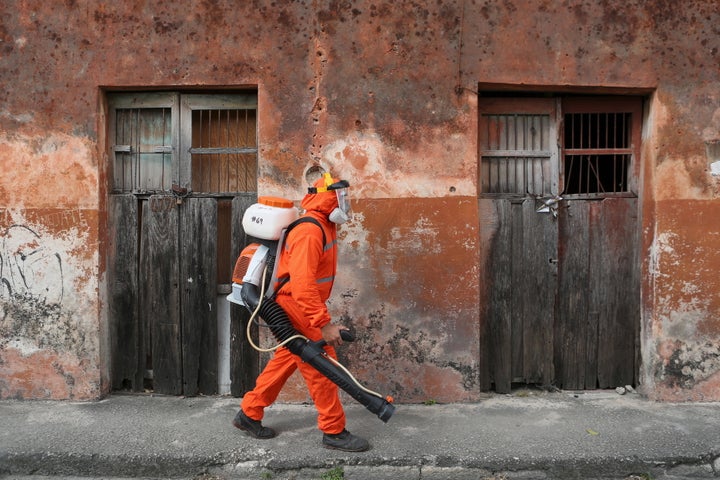 A health worker walks towards a house to fumigate it as part of preventive measures against the Zika virus in Mexico. 