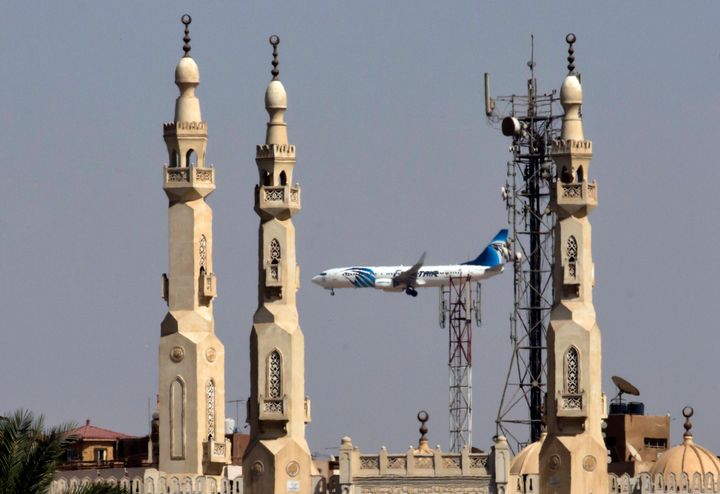 An EgyptAir plane flies past minarets of a mosque as it approaches Cairo International Airport.