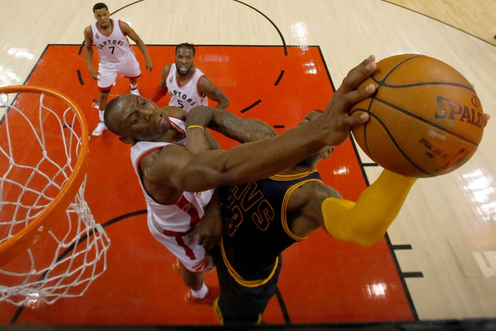 Toronto Raptors center Bismack Biyombo is called for a foul as he stops Cleveland Cavaliers forward LeBron James.