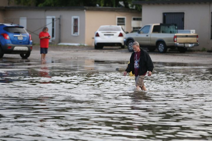 A man walks through the water on Kostoryz Road on Monday, May 16, 2016, in Corpus Christi, Texas. Storms have contributed to ongoing issues with the city's water supply.