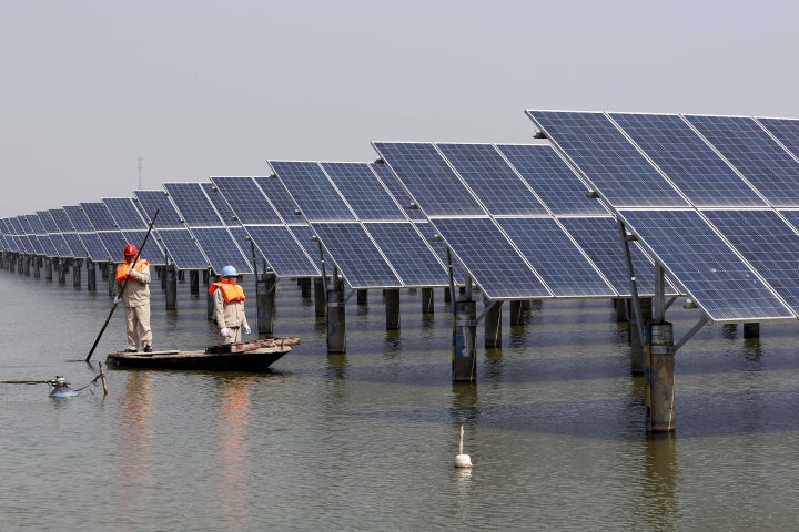 Solar power jobs are increasing worldwide. Take these workers examining solar panels in Jiangsu Province, Chin