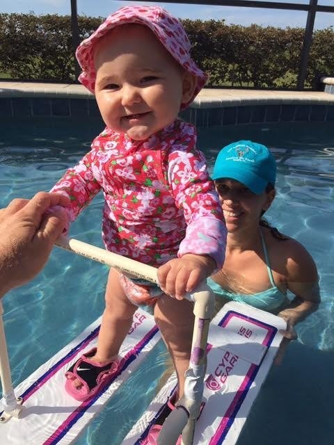 Baby Zyla, whose mother says adores water, is seen trying out a pair of water skis in a backyard pool.