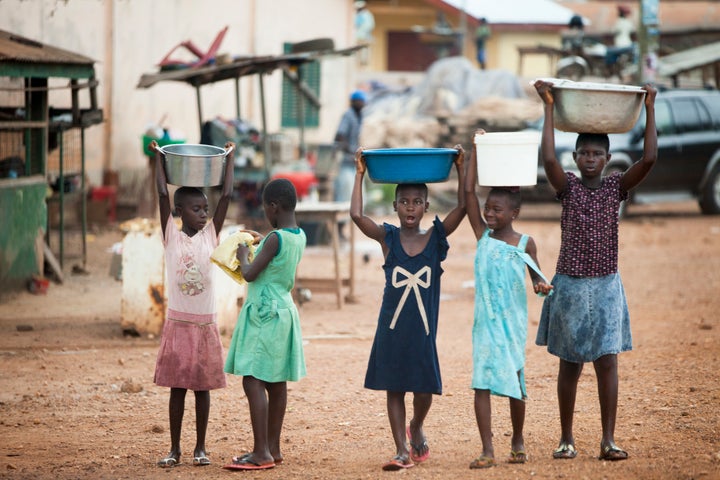 KWAMANG, GHANA - NOVEMBER 10: Young girls carry water on their heads in their cocoa-producing village, on November 10, 2015 in Kwamang, Ghana. There is no running water in the village. Child labor in the cocoa fields was a problem for generations until activists educated farmers that the children should be in school. Now most families won't let their children work on their cocoa farms except on weekends and holidays - and even then, they only help with easy chores. (Photo by Melanie Stetson Freeman/The Christian Science Monitor via Getty Images)