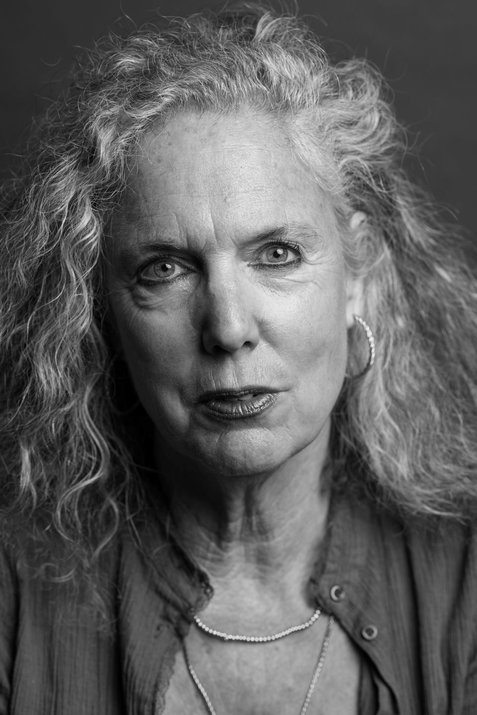 Smoothing out wrinkles.Portrait of an older adult woman with closed eyes  doing a beauty injection. Hands in white gloves hold a syringe.Face lift.  Stock Photo