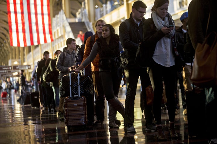 Travelers wait in line before going through Transportation Security Administration (TSA) screening at Ronald Reagan National
