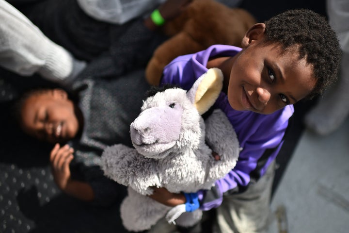 A child smiles during a distribution of meals aboard the rescue ship 'Aquarius', on May 25, 2016 a day after a rescue operation of migrants and refugees off the Libyan coast.