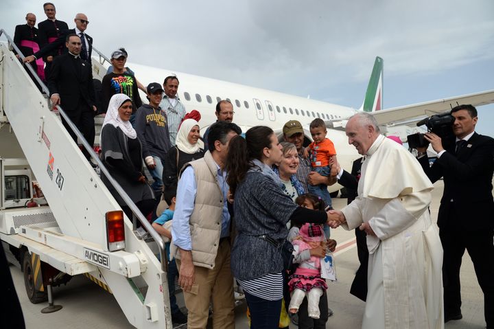 Pope Francis welcomes a group of Syrian refugees after landing at Ciampino airport in Rome following a visit at the Moria refugee camp on April 16, 2016 in the Greek island of Lesbos.