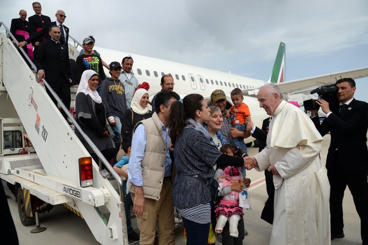 Pope Francis welcomes a group of Syrian refugees after landing at Ciampino airport in Rome following a visit at the Moria ref