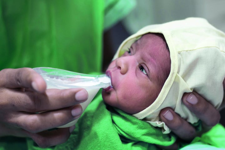 A baby sips from a NIFTY cup, which is designed to help babies who struggle to breastfeed. 