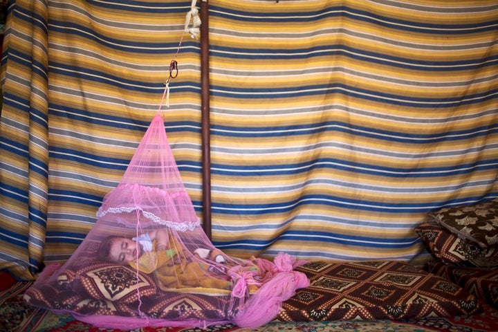 Seven-month-old Syrian refugee Mariam Mohammed, whose family fled from Hama, Syria, sleeps under a mosquito net inside their tent at an informal tented settlement in the Jordan Valley, Jordan.