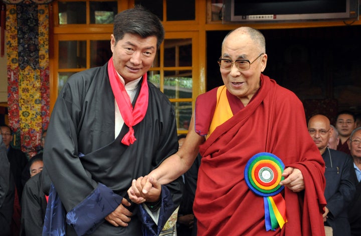 Lobsang Sangay, the prime minister of Tibet's government in exile, stands next to the Dalai Lama as he greets the crowd at his swearing-in ceremony.