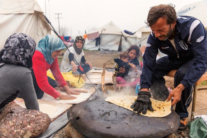 A Syrian family prepares bread to sell from their tent. Using a satellite dish to bake the bread, they start at around 10 a.m. and work most of the day, selling three pieces for 1 euro.
