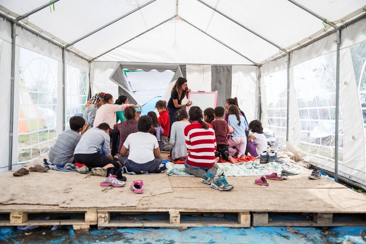 A Palestinian volunteer runs a daily children's English lesson in a donated tent. 