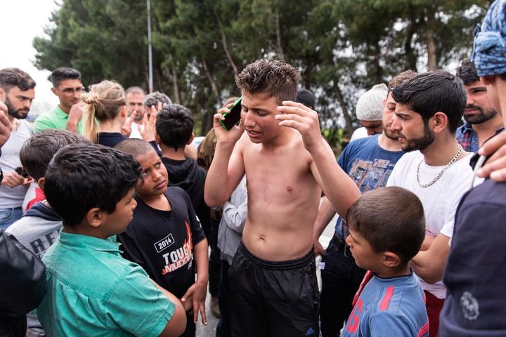 Doused in kerosene, 16-year-old Hesham, an unaccompanied minor, speaks on the phone with a friend after threatening to immolate himself in protest if the Macedonian border did not open within four hours. Hesham's father has not been seen in two years after being kidnapped in Syria, where his mother still lives.