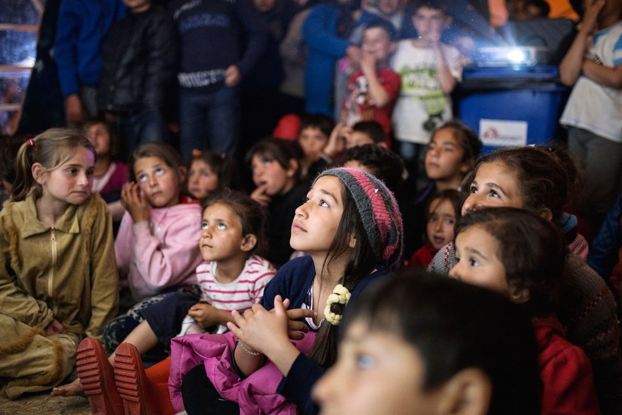 Zainab, 12, watches an episode of Mr. Bean at a gathering organized by a Spanish volunteer. Zainab has been living in Idomeni with her family for a month and a half after fleeing Idlib, Syria. Her 17-year-old brother waits for them in Germany. "There aren't planes that bomb us there. We'll be safe," she says.