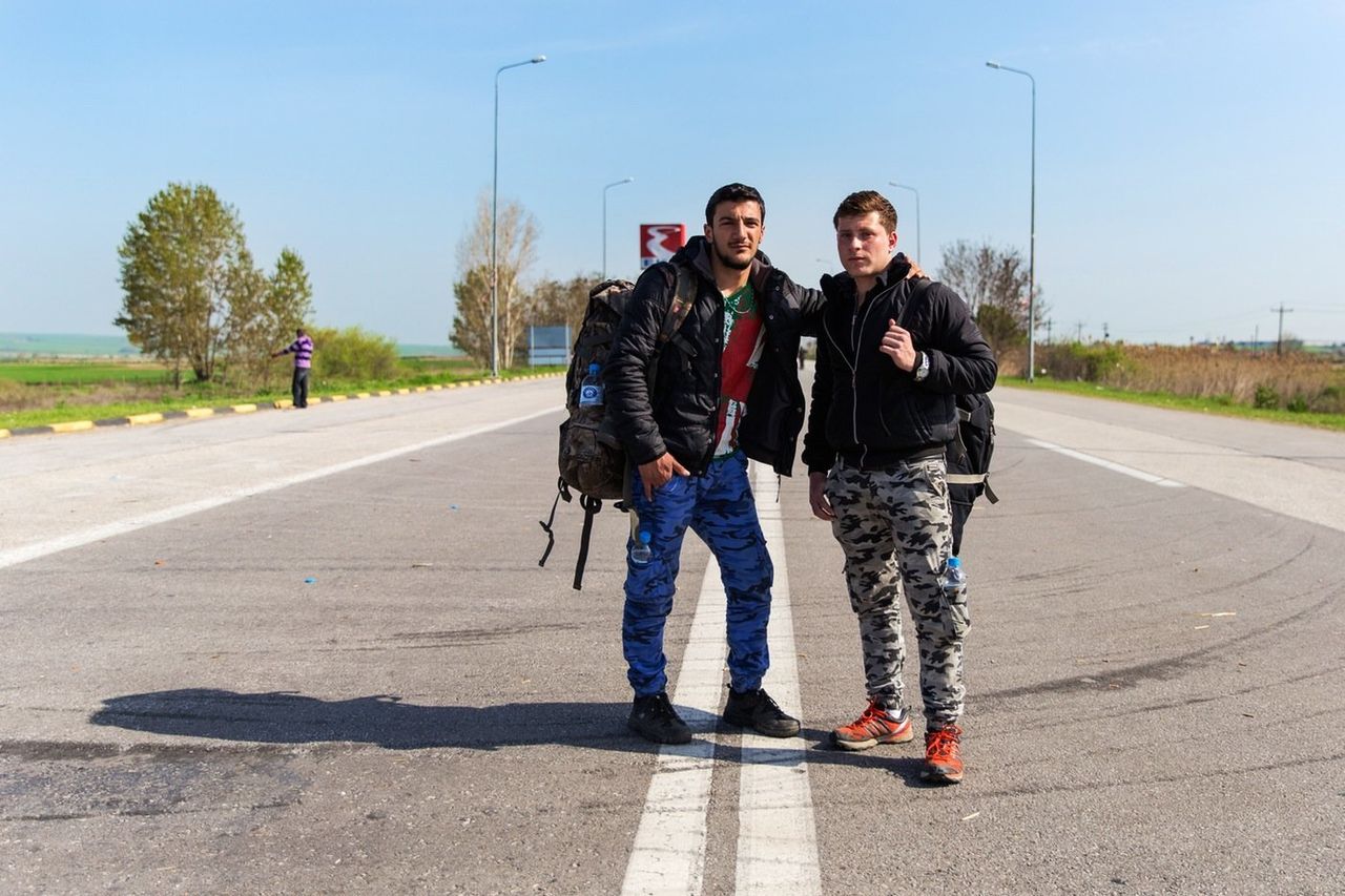 Karam, 19, and Mohammed, 18, both from Hama, Syria, stand in the street with their belongings, preparing to make their way back to their country after 40 days at EKO gas station. 