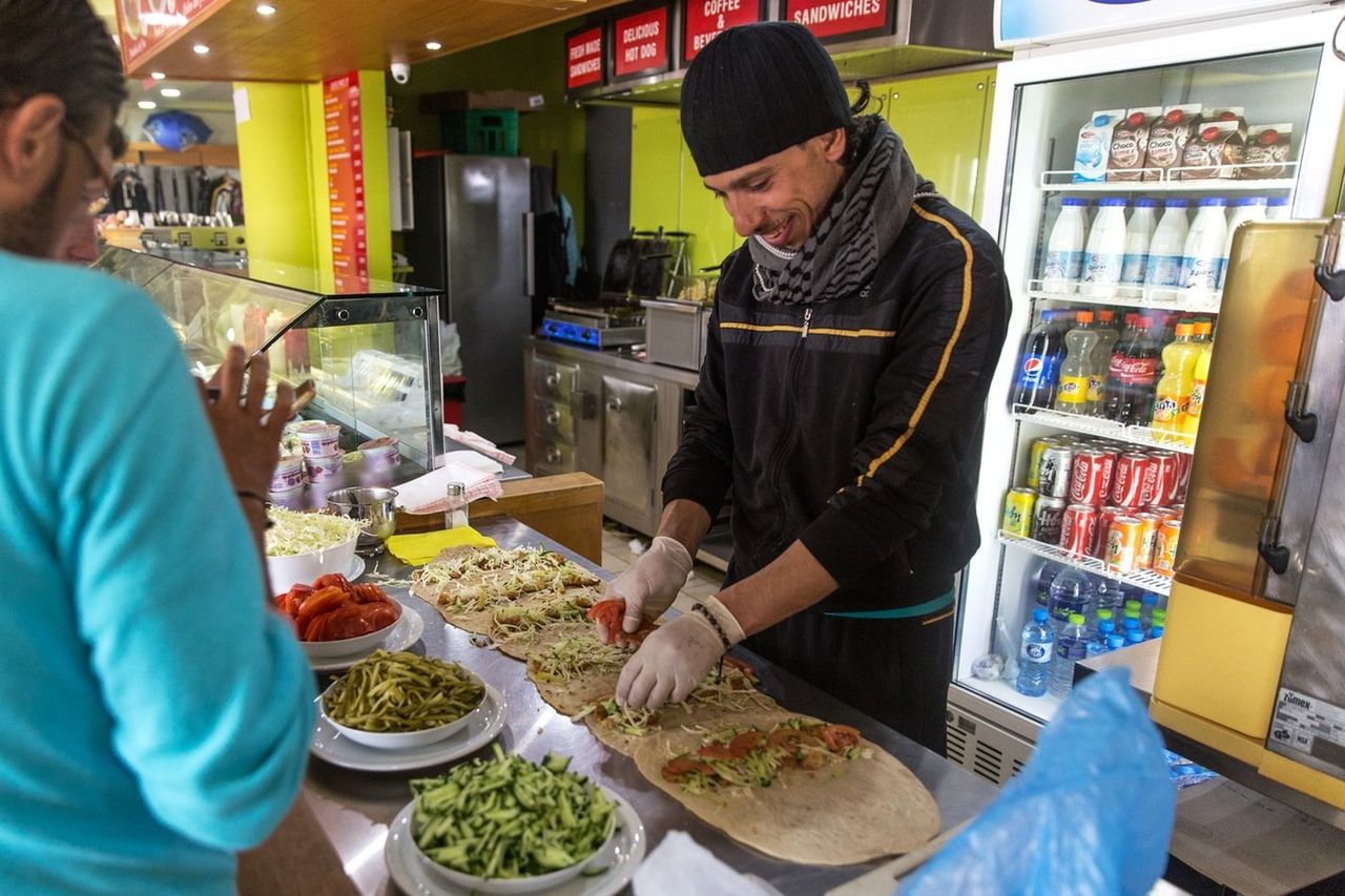 A Syrian prepares falafel in the gas station cafe. The owners allow the former chef to make and sell his street food from the cafe's kitchen for 1 euro a piece, using bread prepared by other refugees in the camp. 
