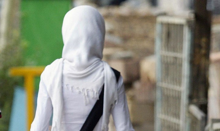 As part of a wider crackdown on behaviors considered to be contrary to Islamic values, authorities punished a group of college students for partying. Here, an unidentified Iranian woman walks on a street in Tehran, on July 13, 2004.