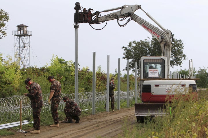 Hungarian soldiers erect a fence on the border with Croatia in September. European measures to stem the flow of migrants and refugees have left thousands stranded on the frontiers of wealthy nations.