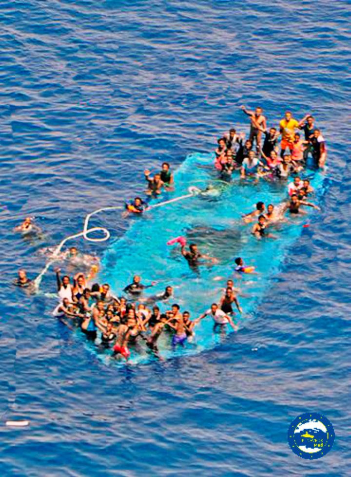Refugees and migrants on a partially submerged boat in the Mediterranean.